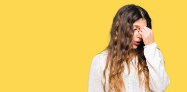 Beyaz kazak yorgun sürtünme burun ve göz yorgunluğu ve baş ağrısı duygu giyen genç güzel kadın. Stres ve hayal kırıklığı kavramı.