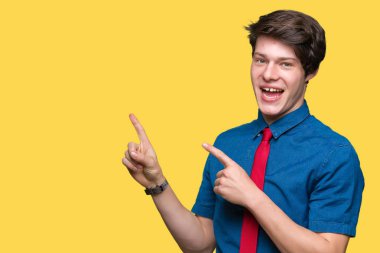 Gülümseyen ve iki elleri ve parmakları ile tarafına işaret kamera bakarak izole arka plan üzerinde kırmızı kravat giyen genç yakışıklı iş adamı.