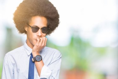 Afro saç gözlük giyen genç Afrikalı Amerikan iş adamı vurguladı ve ağız ısırma çivi elleri ile sinir bakıyor. Anksiyete sorunu.