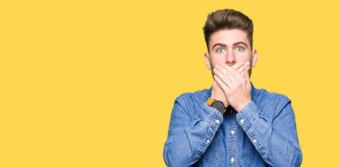 Hata için ellerle ağız kapsayan şok rahat kot gömlek giymiş genç yakışıklı sarışın adam. Gizli kavramı.