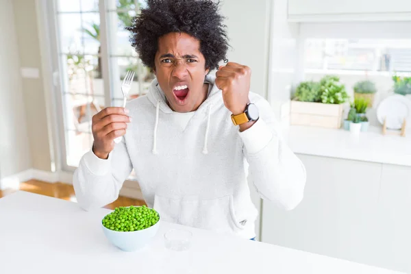 Uomo Afroamericano Mangiare Piselli Verdi Freschi Casa Infastidito Frustrato Gridando — Foto Stock