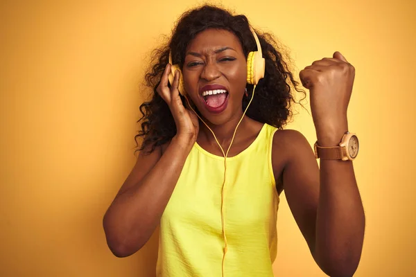 Африканская Американка Слушает Музыку Помощью Наушников Изолированном Желтом Фоне Раздраженный — стоковое фото