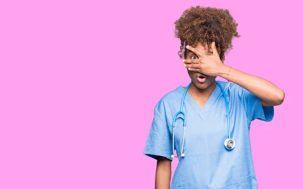 Young African American Doctor Woman Isolated Background Peeking Shock Covering — Stock Photo, Image