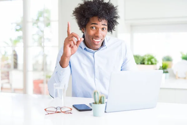 幸せな顔で指を指すアイデアや質問で驚いたラップトップを使用して働くアフリカ系アメリカ人のビジネスマン ナンバーワン — ストック写真