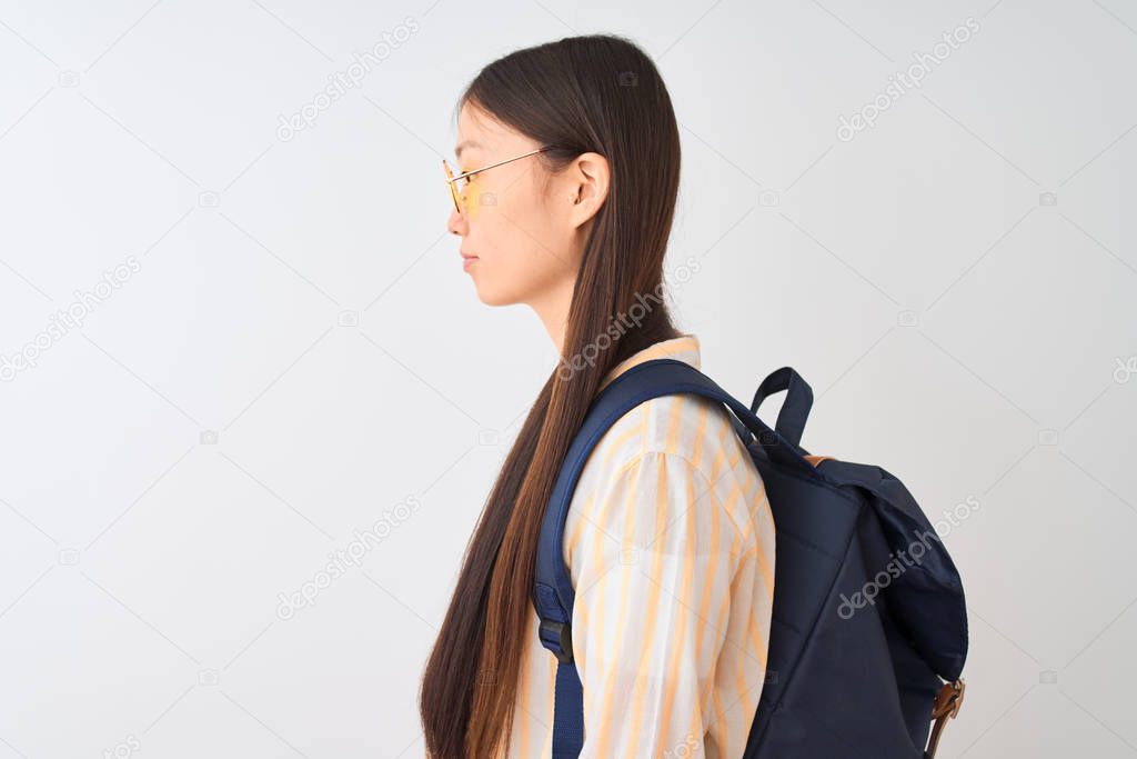 Young chinese student woman wearing glasses and backpack over isolated white background looking to side, relax profile pose with natural face with confident smile.