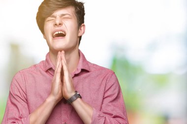 Genç yakışıklı iş adamı yalvarıyor ve umut ifade yüzünde çok duygusal ve endişe ile birlikte elleriyle dua izole arka plan üzerinde. Bağışlanmak. Din kavramı.