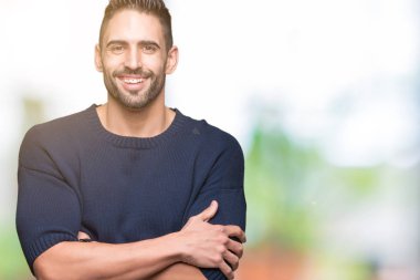 Mutlu yüz ile gülümseyerek kameraya seyir silah geçti arka plan üzerinde kazak giyen genç yakışıklı adam izole. Olumlu bir kişi.