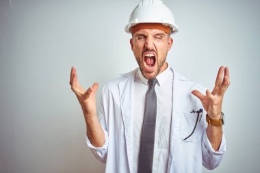 Genç yakışıklı mühendis adam izole arka plan üzerinde emniyet kask giyiyor deli ve silah ile başarı için deli kutlamak kaldırdı ve kapalı gözleri heyecanlı çığlık. Kazanan kavramı