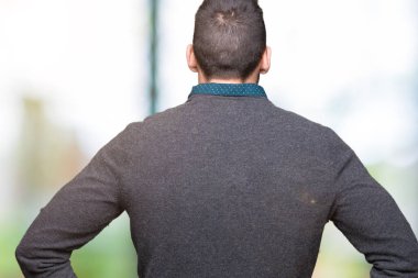 İzole arka plan ayakta geriye doğru uzakta silah ile vücut üzerinde seyir üzerinde gözlük takan genç yakışıklı adam