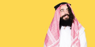 Arap iş adamı ile uzun saç giyen geleneksel keffiyeh eşarp uzak tarafına yüzünde, doğal ifade gülümseme ile arıyorum. Kendine güvenen gülüyor.