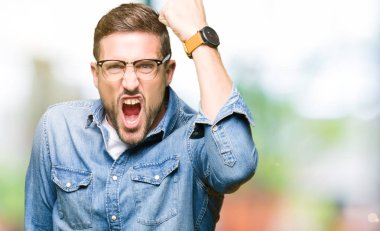 Yakışıklı adam kızgın ve deli yumruk hayal kırıklığı ve öfke ile bağırarak süre öfkeli yükselterek gözlüklü. Öfke ve agresif kavramı.