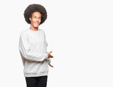 Sportif kazak açık el ile doğal gülümseyen girmek için davet giyen afro saçlı genç Afro-Amerikan adam
