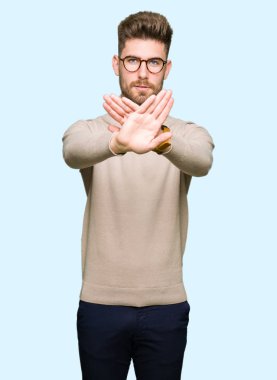 Gözlük takan genç yakışıklı iş adamı ret ifadesi geçiş silah ve avuç içi negatif işareti, öfkeli yüz yapıyor