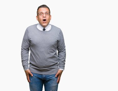 Orta yaş bussines Arap adam gözlüklü izole arka plan korkuyor ve şok sürpriz ifade, korku ve heyecan yüz üzerinden.