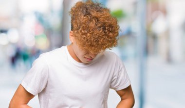 Afro saç ile genç yakışıklı adam rahat beyaz t-shirt mide üzerinde el ile giyiyor çünkü hazımsızlık, ağrılı hastalık duygusunu. Ağrı kavramı.