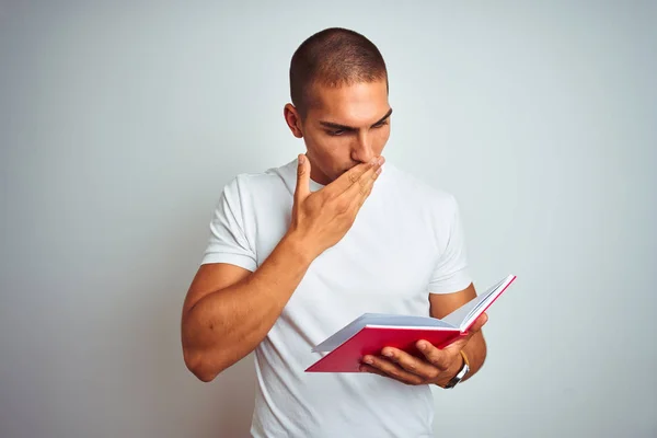 Молодой Красивый Мужчина Читающий Красную Книгу Белом Изолированном Заднем Плане — стоковое фото
