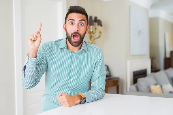 Homem Hispânico Bonito Casa Apontando Dedo Para Cima Com Ideia — Fotografia de Stock