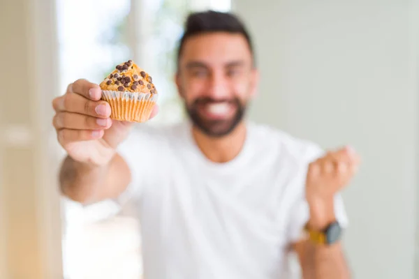 Hombre Hispano Guapo Comiendo Chips Chocolate Muffin Gritando Orgulloso Celebrando — Foto de Stock