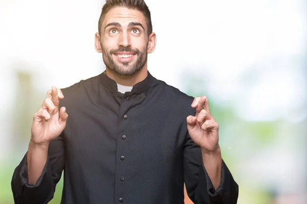 Joven Sacerdote Cristiano Sobre Fondo Aislado Sonriendo Cruzando Los Dedos —  Fotos de Stock