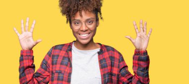 Güzel genç Afro-Amerikan kadın gözlük gösterilen ve parmakları ile işaret izole arka plan üzerinde number ten kendinden emin ve mutlu gülümseyerek süre.