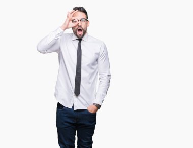 Sürpriz yüz, göz parmaklarının arasından seyir ile ok jest yapıyor izole arka plan üzerinde gözlüklü genç yakışıklı iş adamı şok. İmansız ifade.