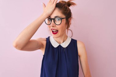 Redhead kadın pigtail zarif elbise ve gözlük izole pembe arka plan üzerinde giyen hata için kafasına el ile şaşırttı, hata hatırlıyorum. Unuttum, kötü bellek kavramı.