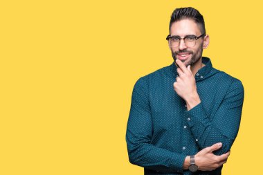 Emin çapraz kollar ve çeneme kaldırdı el ile gülümseme ile kameraya bakarak izole arka plan üzerinde gözlük takan genç yakışıklı iş adamı. Pozitif düşünce.