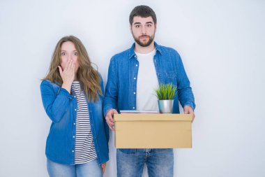 Beyaz izole arka plan kapağı ağız üzerinde yeni bir ev taşımak karton kutu tutan genç çift el hata için utanç ile şok, korku ifadesi, sessizlik, gizli kavramı korkuyor