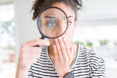 Genç Afrikalı Amerikalı kadın El Büyüteç ile hata için utanç ile şok, korku ifade, sessizlik, gizli kavramı korkuyor ile kapak ağız görünümlü