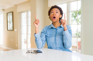 Genç güzel Afrikalı-Amerikalı kadın hayrete ve yukarıya bakıp parmakları ile işaret şaşırttı ve silah kaldırdı.