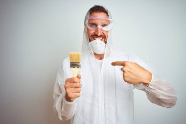 Profesyonel işçi ekipman giyen ressam adam sürpriz yüz kendini işaret parmak ile izole arka plan üzerinde fırça tutarak