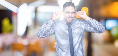 Üzerinde gözlük takan genç iş adamı arka plan gülen çekerek kulakları parmaklar, komik jest ile izole. Seçmelere sorun