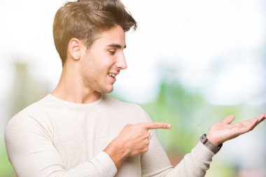 Yakışıklı delikanlı üzerinden hayran ve el ile sunulması ve parmak ile işaret ederken kameraya gülümseyen izole arka plan.