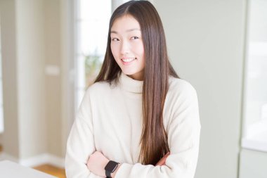 Görünümlü yan ve dik dik bakma uzağa düşünce gülümseyen rahat kazak giyen güzel Asyalı kadın.