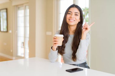 Evde bir fincan kahve içme genç kadın çok mutlu yan el ve parmak ile işaret