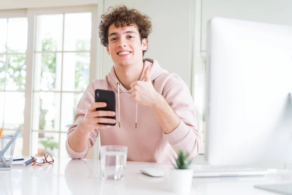 Młody Student Człowiek Pomocą Smartfona Komputera Zadowolony Wielkim Uśmiechem Robi — Zdjęcie stockowe