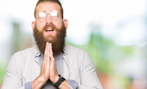 Νέος Ξανθός Άντρας Φορώντας Γυαλιά Ικετεύοντας Και Προσευχόμενοι Χέρια Μαζί — Φωτογραφία Αρχείου