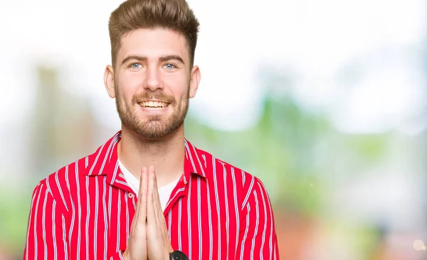 Jovem Homem Bonito Vestindo Camisa Vermelha Orando Com Mãos Juntas — Fotografia de Stock