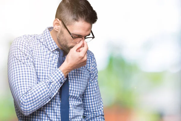 Young business man wearing glasses over isolated background tired rubbing nose and eyes feeling fatigue and headache. Stress and frustration concept.