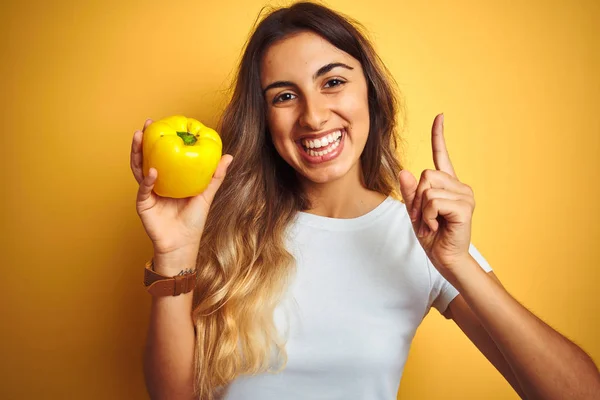 Giovane Bella Donna Che Tiene Pepe Sfondo Giallo Isolato Sorpreso — Foto Stock