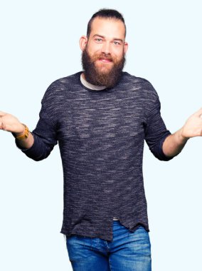 Rahat kazak clueless ve şaşkın bir ifadeyle kollar ve eller kaldırdı giyen genç sarışın adam. Şüphe kavramı.