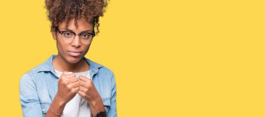 Güzel genç Afro-Amerikan kadın gözlük izole arka plan üzerinde yumruk savunma hareketi, kızgın ve üzgün yüz, sorunu korkuyor ile savaşmaya hazır