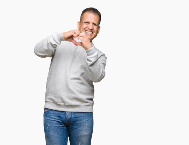 Orta yaş Arap adam aşık kalp simgesi ve elleriyle şekil gösteren gülümseyen izole arka plan üzerinde spor kazak giyiyor. Romantik kavramı.