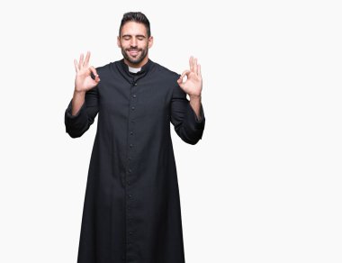 Genç Hıristiyan rahip izole arka plan üzerinde dinlenmek ve gülümseyen gözlerle parmak ile meditasyon jest yapıyor kapalı. Yoga kavramı.