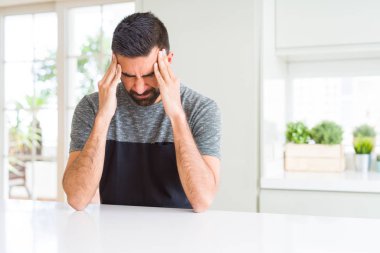Yakışıklı İspanyol adam baş ağrısı umutsuz ve stresli evde rahat t-shirt giyen ağrı ve migren nedeniyle vurguladı. Eller baş.