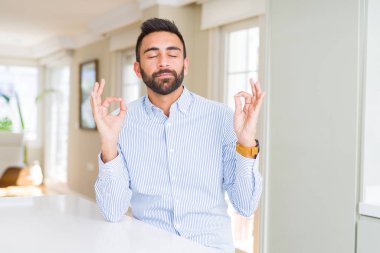 Yakışıklı İspanyol iş adamı rahatla ve gülümseyen gözlerle parmak ile meditasyon jest yapıyor kapalı. Yoga kavramı.