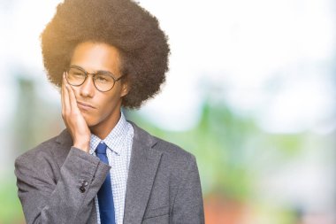 Afro saçlı gözlüklü seyir yorgun ve çapraz kolları olan depresyon sorunları ile sıkılmış düşünme genç Afro-Amerikalı iş adamı.
