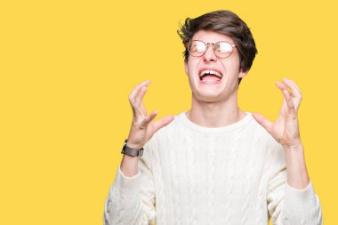 Üzerinde gözlük takan genç yakışıklı adam arka plan deli izole ve deli bağırarak ve agresif ifade ve silah kaldırdı bağırıyor. Hayal kırıklığı kavramı.