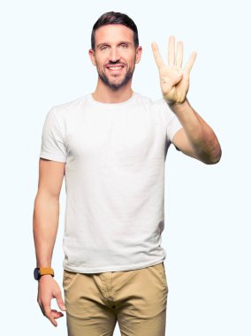 Yakışıklı adam gösterilen ve parmakları ile işaret casual beyaz t-shirt giyen süre kendinden emin ve mutlu gülümseyerek dört numara.