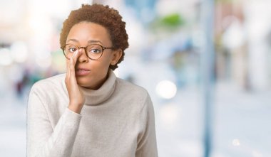 Genç güzel Afrikalı Amerikalı kadın gizli söylenti söyleyerek ağız üzerinde izole arka plan el üzerinde gözlük giyiyor, kötü niyetli konuşma konuşma fısıldayan